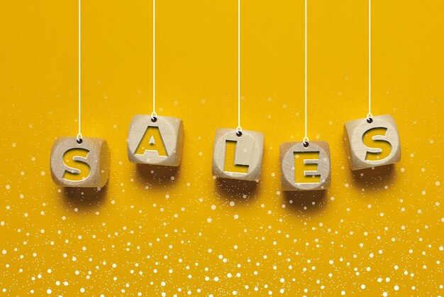 Wooden cubes with SALE text Yellow background with snowflakes copy space banner