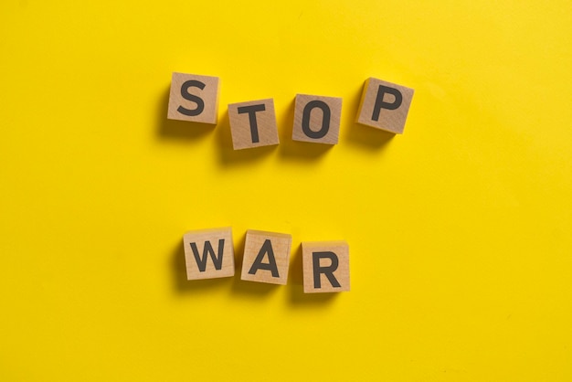 The wooden cubes with stop war text on pastel background