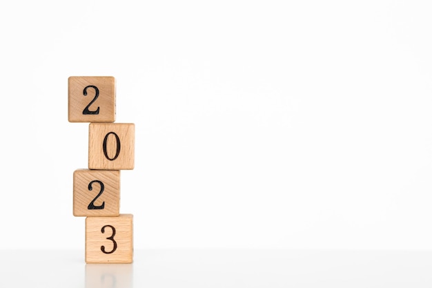 Wooden cubes with text 2023 written in black on a wooden block surface Happy New Year concept