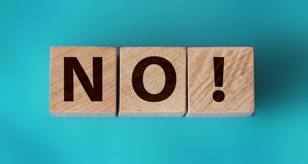 Photo wooden cubes with text no on a blue background negative answer concept no risk no violence or no discrimination concept