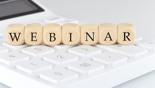 Деревянные кубики с текстом WEBINAR на калькуляторе, бизнес