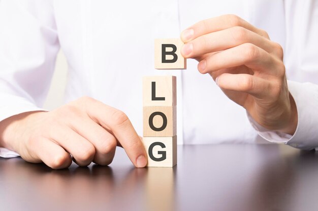 ブログという単語を持つ木製の立方体は、手が文字 b の立方体を置きます