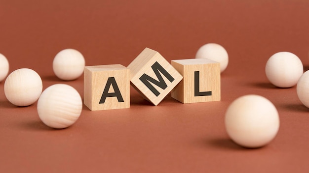 Wooden cubes with word AML on brown background front view