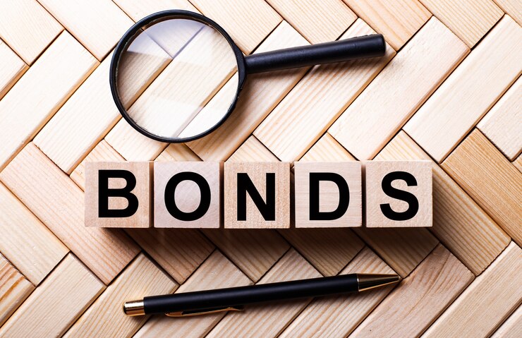 फोटो wooden cubes with the word bonds stand on a wooden background between a magnifying glass and a handle