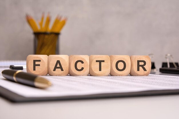 Деревянные кубики со словом FACTOR на офисном столе