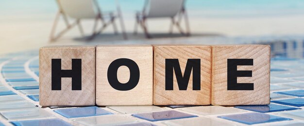 Wooden cubes with the word home home on a wooden background Emigration consept