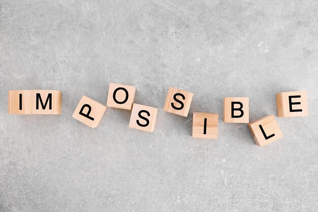 Wooden cubes with word IMPOSSIBLE on light background