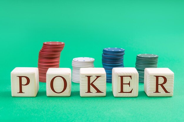 Photo wooden cubes with word poker and poker chips on a green background