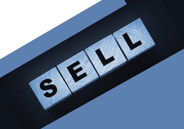 Деревянные кубики со словом "продать" на темном фоне Концепция покупок