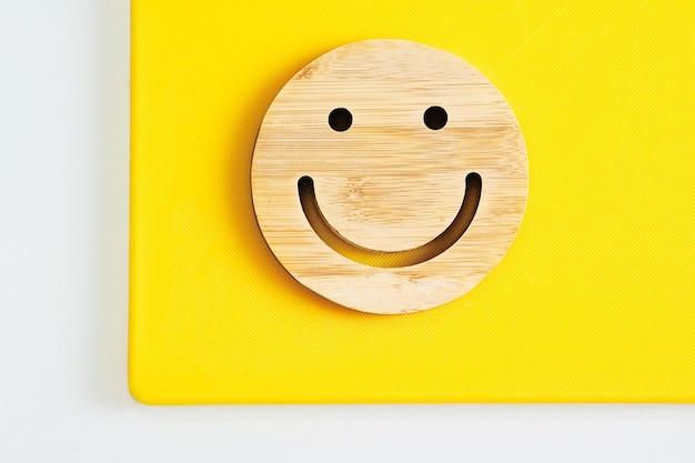 Wooden cup holder in shape of smile face on yellow background smiley emoji happy face