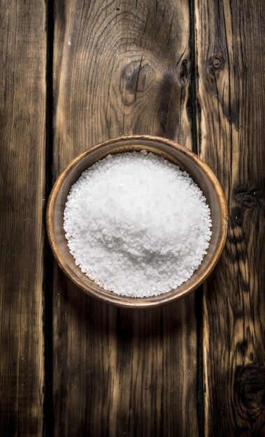 Wooden Cup with salt on a wooden background