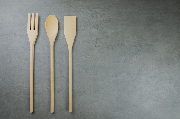 Wooden cutlery on gray background.