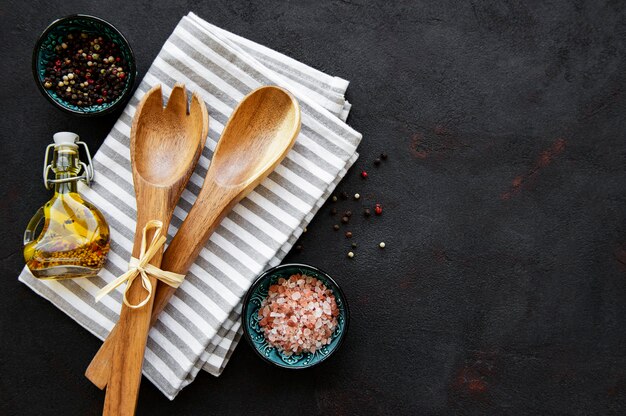 Wooden cutlery kitchen ware and spices on a black background