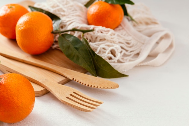 Photo wooden cutlery set and mandarins