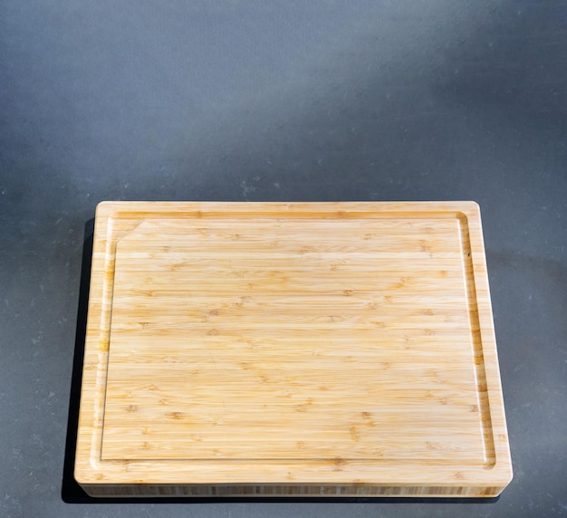 Wooden cutting board on a black stone flat surface background