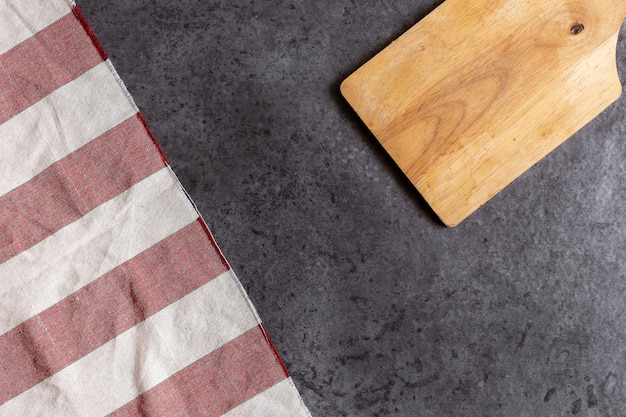 Wooden cutting board on black table background