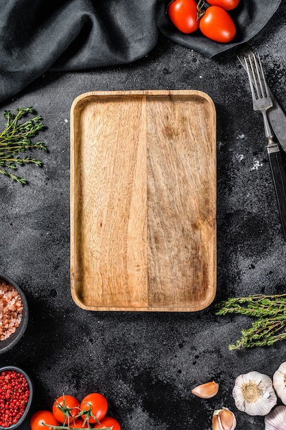 Wooden cutting board  in center of Fresh raw greens