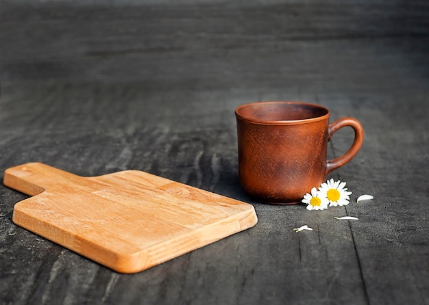 Photo wooden cutting board and mug on black background