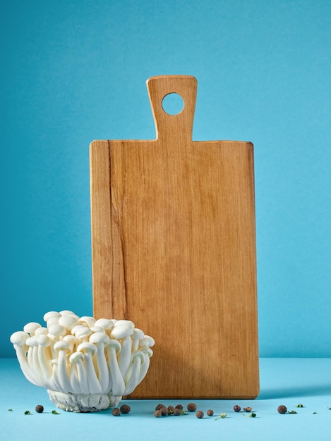 wooden cutting board and mushrooms on blue background