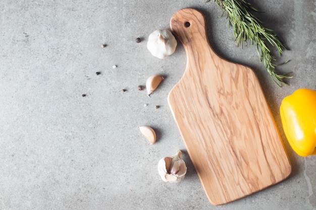 新鮮なハーブと素朴な木のテーブルで生野菜と木製のまな板。上面図。料理の背景。