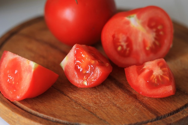 A wooden cutting board with tomatoes on it