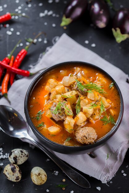 on a wooden cutting kitchen board, homemade food, clay pot soup, potatoes and meat, cherry tomatoes,