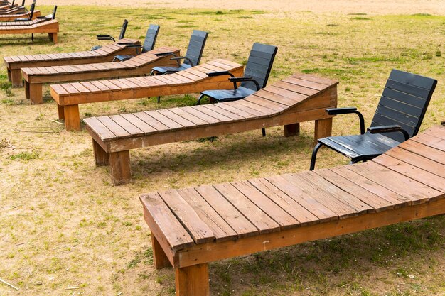 Wooden deck chairs and chairs on the sandy beach of the lake