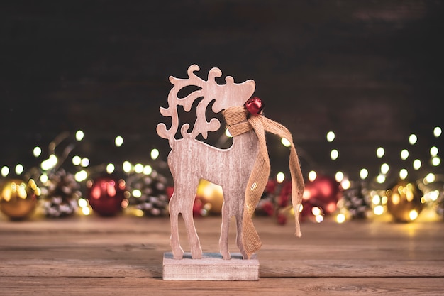 Giocattolo di cervo in legno, bokeh, oro di natale, palline rosse