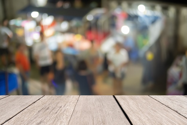 Photo wooden desk in front blurred night market abstract, presentation and template concept