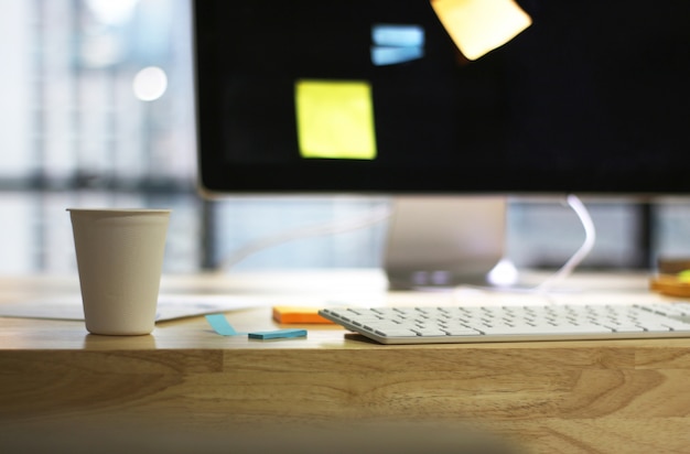 Wooden desk table office with computer screen and coffee cup