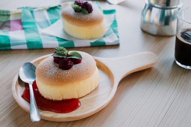 写真 朝の近接で日本のチーズケーキとコーヒーを飲む木製の机