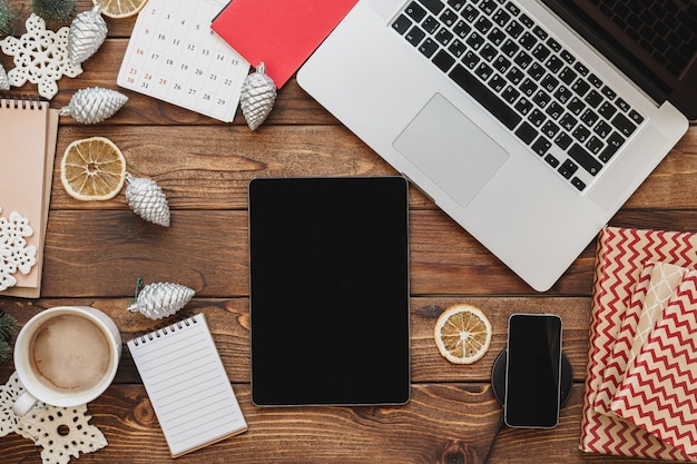 wooden desktop with computer, office supplies and christmas decorations