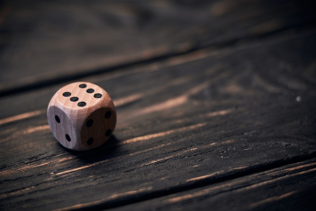 Wooden dice on old wood table. number six on the top side.