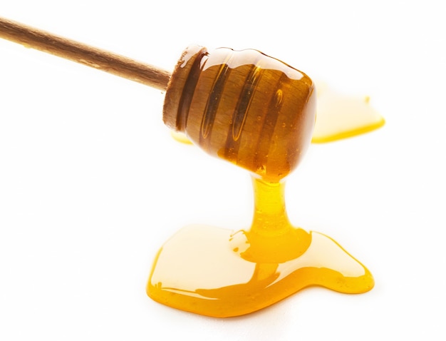 wooden dipper and honey isolated on white background, cutout