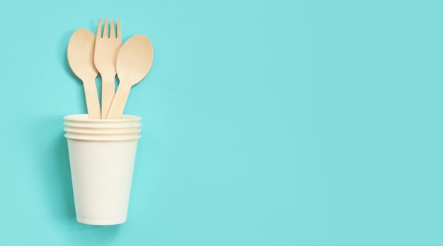 Wooden disposable forks and spoons in a paper cup top view Eco friendly
