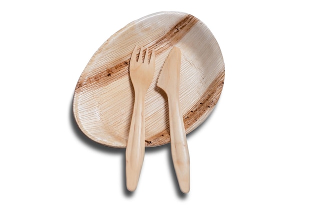 Деревянная одноразовая посуда с тарелкой и столовыми приборами, такими как нож и вилка на белом фоне.