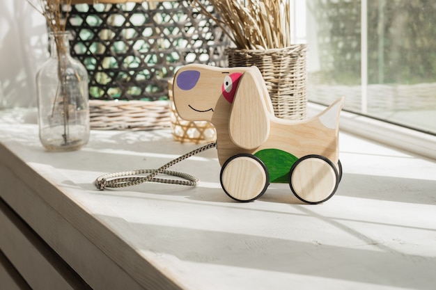 Photo wooden dog on wheels of beech on table