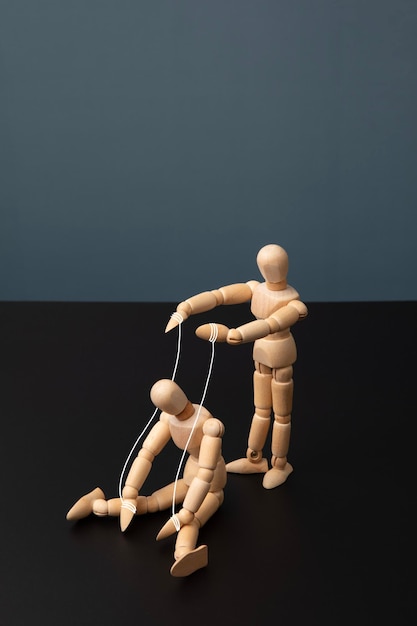 a wooden doll that controls a sitting wooden doll
