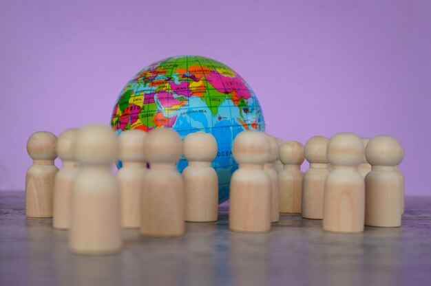 Wooden dolls and earth globe world population day concept