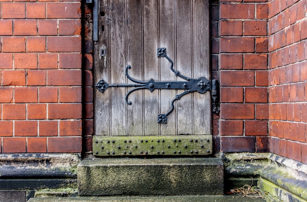 Porta in legno e muro di mattoni in una vecchia cattedrale