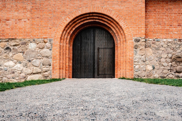 Porta di legno nel castello di mattoni rossi.