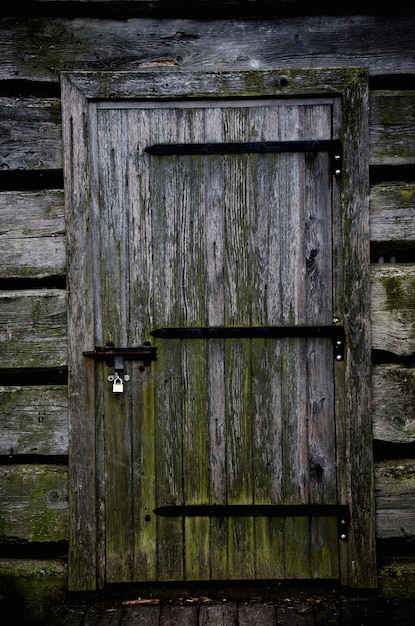 Porta di legno di una casa abbandonata tenebrosa