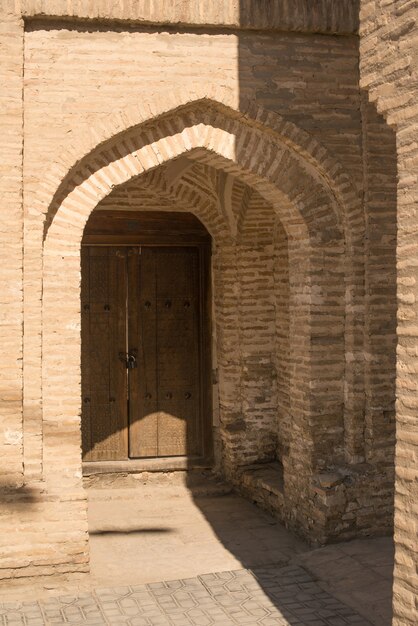 Wooden door with ancient traditional Asian ornamentation and mosaics Architecture of Central Asia