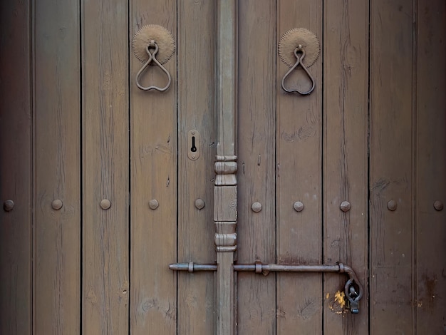 Photo wooden door with iron locking gear closeup