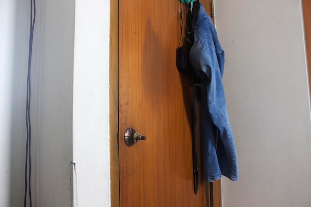 wooden door with a lock and a hanging jeans pant