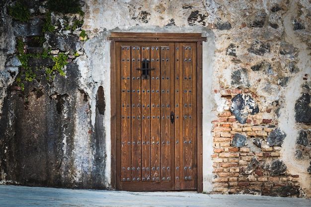 Wooden door with rivets on stone wall