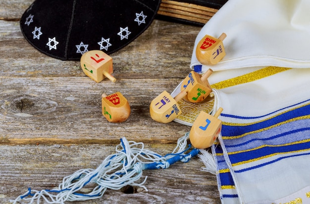 Wooden dreidel for Hanukkah on light background