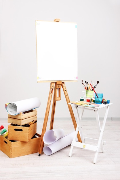 部屋にきれいな紙と画材を備えた木製イーゼル
