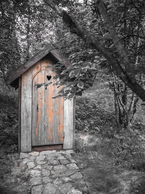 Foto toilette ecologica in legno per il compostaggio in campagna con una forma di cuore nella porta