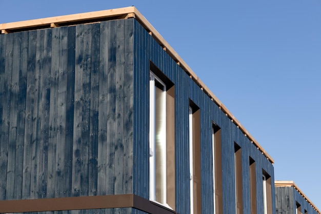 Wooden facade of a separate modular house with windows Closeup